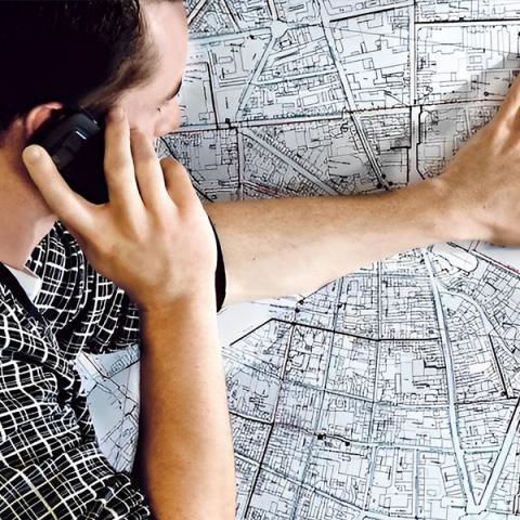 Homme au téléphone avec main sur une carte