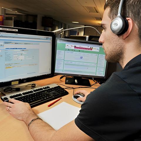 Homme à son bureau derrière son écran d'ordinateur